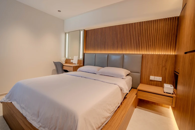 Contemporary master bedroom design with a wooden headboard and bedside table setup.