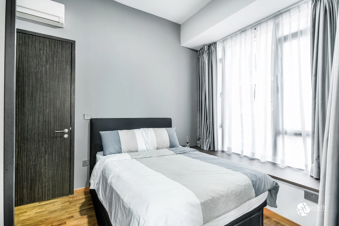 Small bedroom with a simple design featuring natural light from large windows.