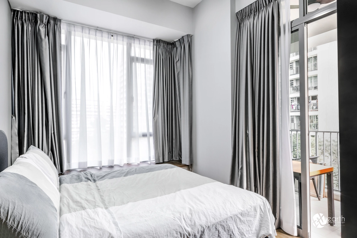 A well-lit small bedroom with neutral tones and floor-to-ceiling curtains.