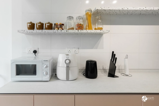 Beige lower cabinets complemented by durable black countertops and a clean white backsplash.