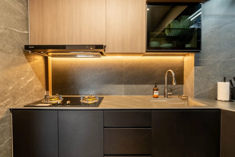 Sleek black matte cabinet design paired with wood-tone upper units and warm under-cabinet lighting.