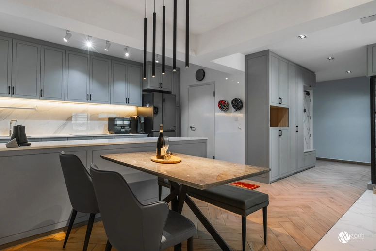 Elegant dining area adjoining a kitchen with gray cabinetry and a marble countertop.