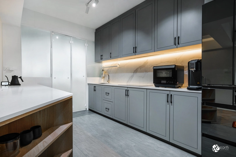 Contemporary kitchen design with gray cabinets, warm lighting, and sleek flooring.