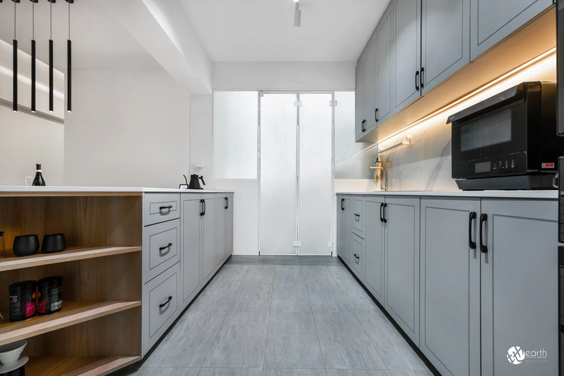 Spacious kitchen layout with gray shaker-style cabinets and open shelving for additional storage.