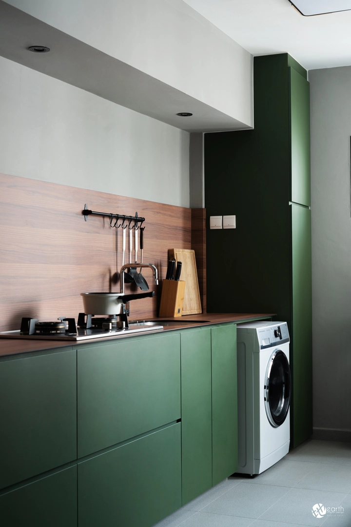 Modern kitchen layout with matte green cabinetry and integrated storage solutions.