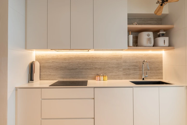 Compact kitchen with a marble backsplash and efficient cabinetry to maximize space.