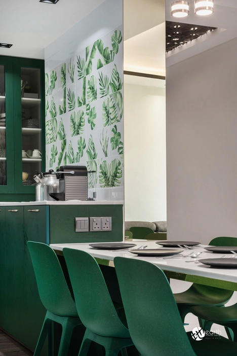 Compact kitchen layout with green cabinets and functional design elements.