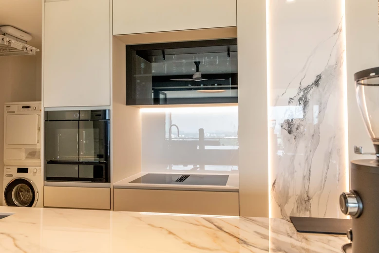 Modern kitchen with sleek appliances, marble surfaces, and integrated cabinetry.