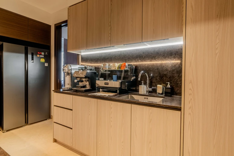 Contemporary kitchen featuring a stainless steel refrigerator, black marble backsplash, and minimalist design.