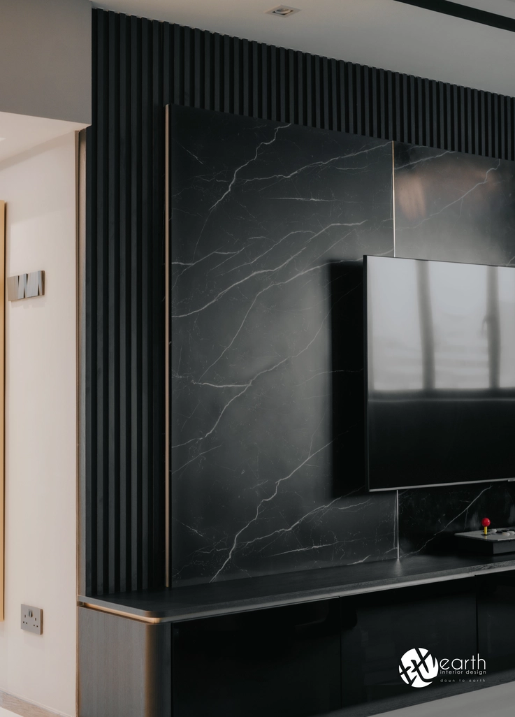 Luxurious black marble TV feature wall with sleek storage cabinets for a modern living room.