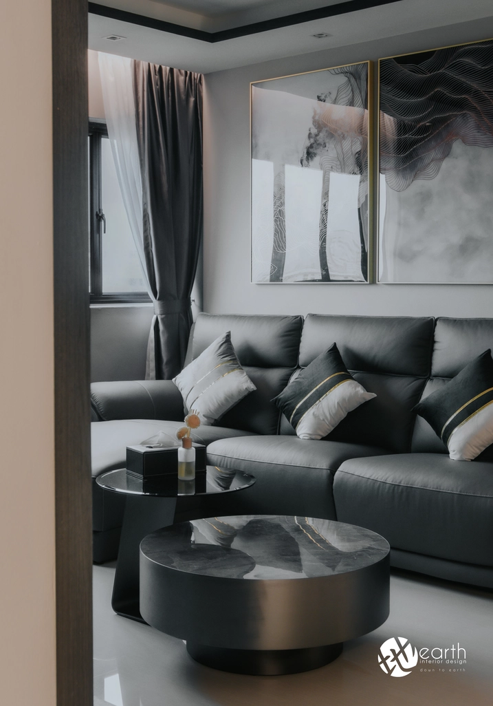 Modern grey sofa with monochromatic art pieces, creating a sophisticated and stylish ambiance.