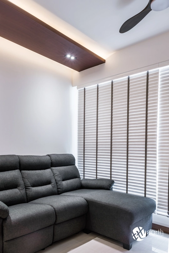 Close-up of a modern grey sofa under ambient ceiling lights, perfect for compact Singapore homes.