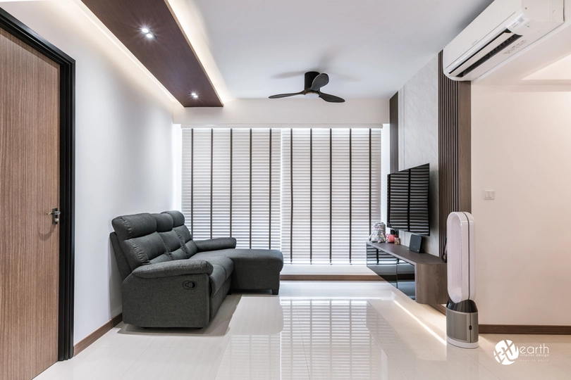 Minimalist living room with a sleek sofa and ceiling fan in a Singapore HDB flat.